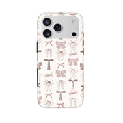Bow Collection iPhone 17 Pro case — cream and brown bows, dual-layer black buttons